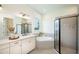 Bright bathroom features double sinks, a soaking tub, and a glass-enclosed shower with modern finishes at 26908 Victoria Pl, Punta Gorda, FL 33955