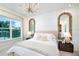 Serene bedroom with textured walls, large mirrors, and views of the outdoor scenery at 26908 Victoria Pl, Punta Gorda, FL 33955
