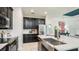 Modern kitchen featuring stainless steel appliances, sleek dark cabinetry, and a spacious island with a sink at 26931 Lark Ct, Punta Gorda, FL 33955