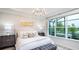 Bright main bedroom featuring a cozy bed, decorative lighting, and a large window overlooking the screened porch at 26936 Lark Ct, Punta Gorda, FL 33955
