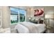 Comfortable bedroom offers soft lighting, a decorative bed and a large window overlooking the backyard at 26936 Lark Ct, Punta Gorda, FL 33955