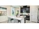 Modern kitchen features a center island with seating, sleek stainless steel appliances, and dark cabinetry at 26936 Lark Ct, Punta Gorda, FL 33955