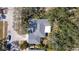 Birds-eye view of a home featuring a gray roof, lush landscaping, and a private driveway with multiple cars at 2903 Mayflower St, Sarasota, FL 34231