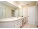Bathroom with a large mirror, white cabinets, and neutral tile flooring at 2903 Mayflower St, Sarasota, FL 34231