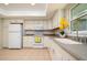 Bright kitchen with white appliances and cabinets, and window view at 2903 Mayflower St, Sarasota, FL 34231