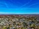 Expansive aerial shot of a community featuring homes, ponds, trees, and a distant cityscape at 303 Grayston Pl # C133, Sun City Center, FL 33573