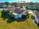 Back aerial view of a home showcasing the lush lawn, tropical landscaping, and lanai at 303 Grayston Pl # C133, Sun City Center, FL 33573