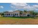 Well-kept backyard with a screen enclosed lanai, complemented by lush tropical landscaping at 303 Grayston Pl # C133, Sun City Center, FL 33573