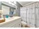 Stylish bathroom with a white vanity, seashell-themed shower curtain, and modern fixtures at 303 Grayston Pl # C133, Sun City Center, FL 33573