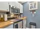 Kitchen featuring stainless steel appliances, white cabinets and butcher block countertops at 303 Grayston Pl # C133, Sun City Center, FL 33573