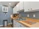Kitchen featuring white cabinets, butcher block countertops, and stainless steel sink at 303 Grayston Pl # C133, Sun City Center, FL 33573
