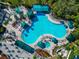 Aerial view of a resort style outdoor swimming pool with lounge chairs, umbrellas, and tropical landscaping at 303 Grayston Pl # C133, Sun City Center, FL 33573