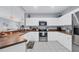 Open kitchen featuring plenty of counter space, white cabinets, and modern appliances, and a dining area at 308 28Th W St, Palmetto, FL 34221