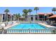 Sparkling community pool surrounded by palm trees and lounge chairs for relaxing at 3231 Beneva Rd # 101, Sarasota, FL 34232