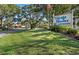Well-maintained Village Brooke Condominiums sign surrounded by lush green grass and mature trees at 3231 Beneva Rd # 101, Sarasota, FL 34232