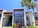 Charming condo building with a red tile roof and a combination of white and dark painted exterior walls at 3231 Beneva Rd # 101, Sarasota, FL 34232