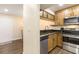 Cozy kitchen with wood cabinets, black counters, stainless steel appliances and updated fixtures at 3231 Beneva Rd # 101, Sarasota, FL 34232