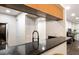 Close-up of a well-maintained kitchen bar, showcasing the modern black faucet, granite countertops, and access to living area at 3231 Beneva Rd # 101, Sarasota, FL 34232