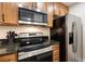 Modern kitchen with wood cabinets, stainless steel appliances and black countertops at 3231 Beneva Rd # 101, Sarasota, FL 34232