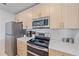 A kitchen with stainless steel appliances, white countertops, and light wood cabinets at 332 Cocoanut Ave # 406, Sarasota, FL 34236