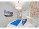 Bright main bedroom featuring a TV, decorative wall hanging, and accents of blue bedding at 332 Cocoanut Ave # 406, Sarasota, FL 34236
