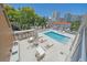 Aerial view of an urban rooftop pool featuring lounge chairs, dining tables, and city views at 332 Cocoanut Ave # 406, Sarasota, FL 34236