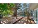 Backyard deck and pool are surrounded by greenery at 3716 Camino Real, Sarasota, FL 34239