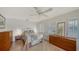 Light-filled bedroom with tile floors, shuttered windows, ceiling fan, and neutral decor at 3716 Camino Real, Sarasota, FL 34239