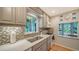 Kitchen featuring wood floors, a mosaic tile backsplash, light countertops, and stainless sink at 3716 Camino Real, Sarasota, FL 34239