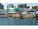 Luxury yachts docked in a marina, featuring a modern building with large windows and waterfront views at 3716 Camino Real, Sarasota, FL 34239