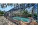 Enclosed swimming pool with screened in enclosure and brick pool deck at 3716 Camino Real, Sarasota, FL 34239