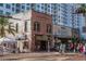 Charming street view with retail businesses, pedestrian activity, and brick buildings in a bustling downtown area at 3716 Camino Real, Sarasota, FL 34239