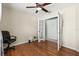 Bedroom with wood floor, closet, glass door, and black office chair at 406 116Th E St, Bradenton, FL 34212