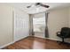 Bedroom with light walls, wood floor, closet, window with blinds, and black office chair at 406 116Th E St, Bradenton, FL 34212