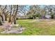 Park-like setting with benches, chairs and green lawn with distant views of a playground and pond at 406 116Th E St, Bradenton, FL 34212