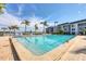 Refreshing outdoor pool with lounge chairs, palm trees, and scenic views of the waterfront at 4390 Exeter Dr # I305, Longboat Key, FL 34228