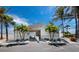 Exterior of beachside building featuring beachfront access, covered picnic area, and lush tropical palms at 4400 Exeter Dr # J-201, Longboat Key, FL 34228
