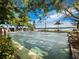 Outdoor bocce court featuring lush, mature landscaping, picnic tables, and scenic waterfront views at Longboat Harbour at 4400 Exeter Dr # J-201, Longboat Key, FL 34228