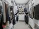 Walk in closet with hanging clothes, shelves with boxes, and stacked drawers at 4400 Exeter Dr # J-201, Longboat Key, FL 34228