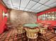 Game room with a poker table, brick accent wall, and unique light fixtures for entertaining guests at 4400 Exeter Dr # J-201, Longboat Key, FL 34228
