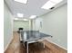 Community game room features a ping pong table with wood-look flooring, light green walls, and a white door at 4400 Exeter Dr # J-201, Longboat Key, FL 34228