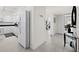 Hallway with white walls and tile flooring, connecting to a kitchen, living area, and other rooms at 4400 Exeter Dr # J-201, Longboat Key, FL 34228