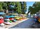 Community kayak storage with colorful boats on racks, under the shade of lush trees and a clear blue sky at 4400 Exeter Dr # J-201, Longboat Key, FL 34228