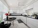 Bright kitchen with white cabinets, black counters, stainless appliances, and a breakfast nook with a view at 4400 Exeter Dr # J-201, Longboat Key, FL 34228