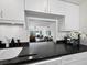 Updated kitchen with granite countertops and a view into the adjacent living area at 4400 Exeter Dr # J-201, Longboat Key, FL 34228