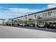View of a covered parking area with multiple vehicles parked in assigned spaces at the condo complex at 4400 Exeter Dr # J-201, Longboat Key, FL 34228