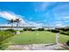 Beautiful putting green area with water views, palm trees, and lush landscaping at Longboat Harbour community at 4400 Exeter Dr # J-201, Longboat Key, FL 34228