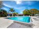 Inviting community swimming pool featuring lounge chairs, palm trees, and beautiful landscaping at Longboat Harbour at 4400 Exeter Dr # J-201, Longboat Key, FL 34228