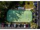 Aerial view of a well-maintained tennis court surrounded by lush greenery and parking spaces at Longboat Harbour at 4400 Exeter Dr # J-201, Longboat Key, FL 34228