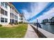 Waterfront property with boat dock, green grass, and waterfront views at 4400 Exeter Dr # J-201, Longboat Key, FL 34228